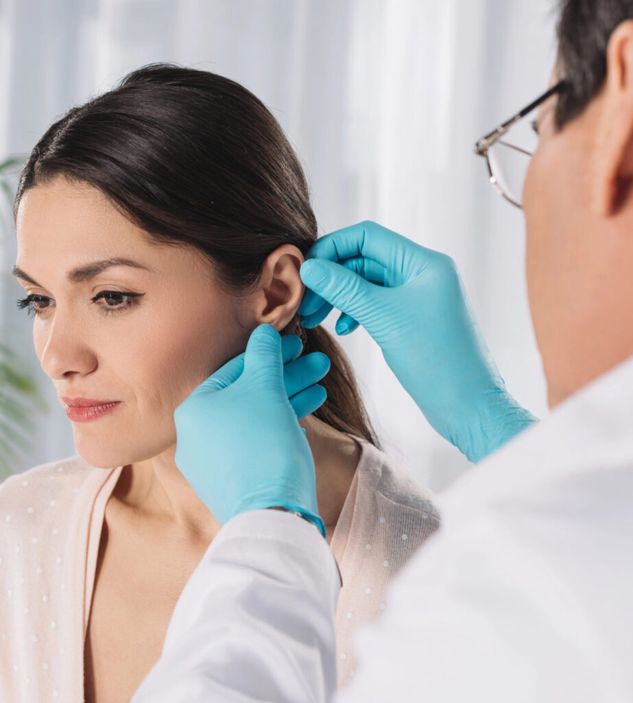 un spécialiste oscultant l'oreille d'une femme